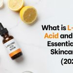 A glass dropper bottle of pure L-ascorbic acid face serum resting next to fresh orange slices and green botanical leaves.