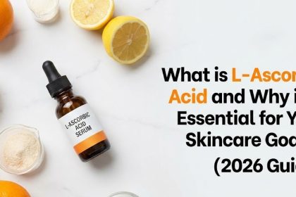 A glass dropper bottle of pure L-ascorbic acid face serum resting next to fresh orange slices and green botanical leaves.