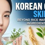 A smiling woman applying a soothing, natural green tea and aloe vera mist to her radiant, glass-like skin.