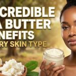 A jar of creamy, unrefined shea butter resting next to raw shea nuts on a wooden table.
